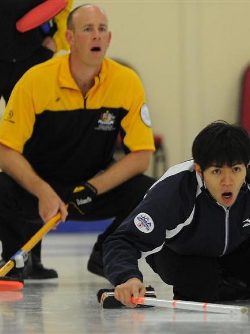 Japan's Yusuke Morozumi (right) watches his stone as Australia's Sean Hall looks on during Asia...