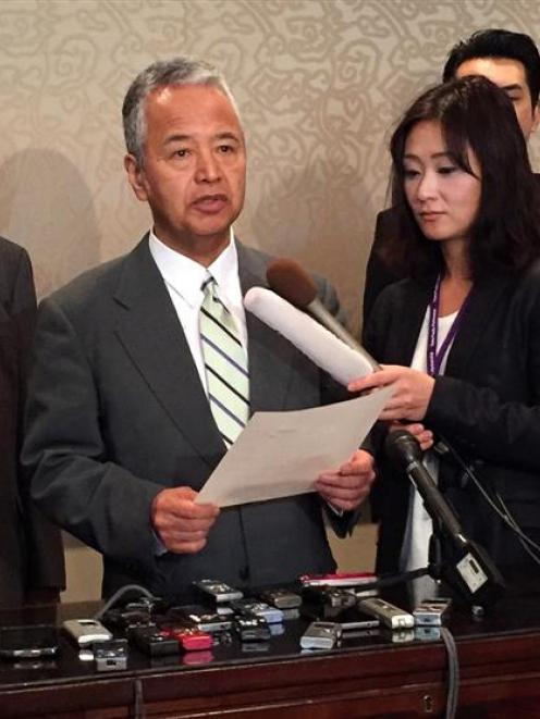 Japanese trade minister Akira Amari (centre) speaks to media during a break in the Trans-Pacific...