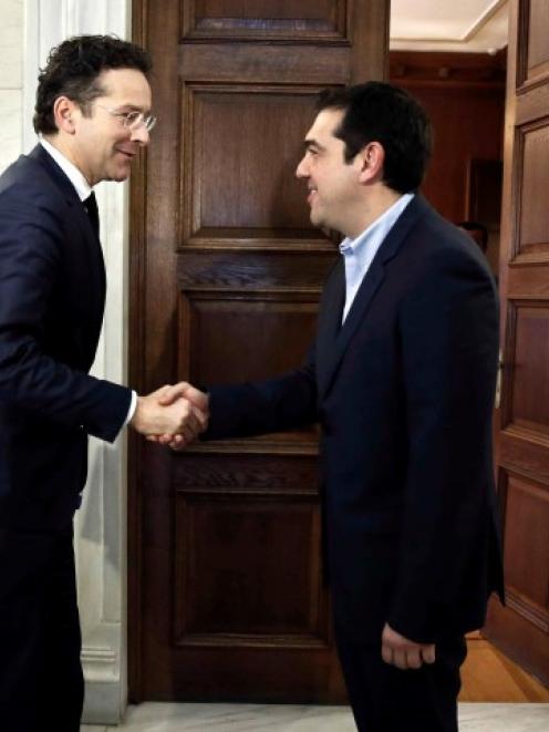 Jeroen Dijsselbloem (L), head of the euro zone finance ministers' group, is welcomed by Greece's...