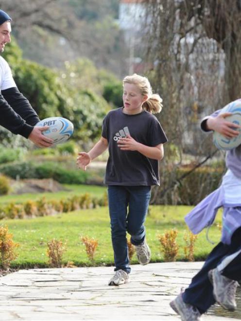 Jerram Huston (above) passes a rugby ball to Bianca Park (9), of Dunedin, as Branwen Jones (9),...