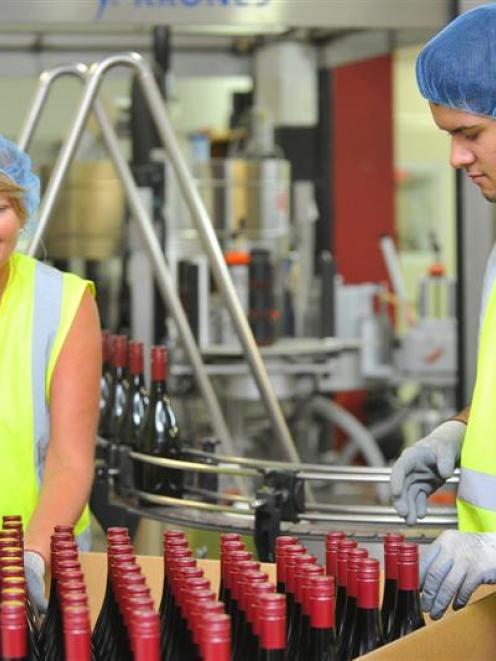 Jo Lunn and Riley Fraser, both of Cromwell, pack freshly bottled wine at VinPro in Cromwell on...
