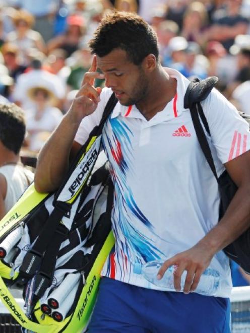 Jo-Wilfried Tsonga of France leaves the court after his loss to Martin Klizman of Slovakia in...