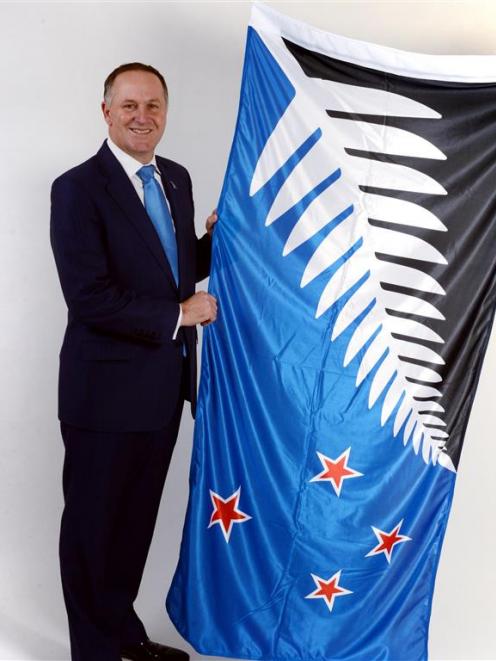 John Key with the Kyle Lockwood-designed flag that was defeated in the referendum.
