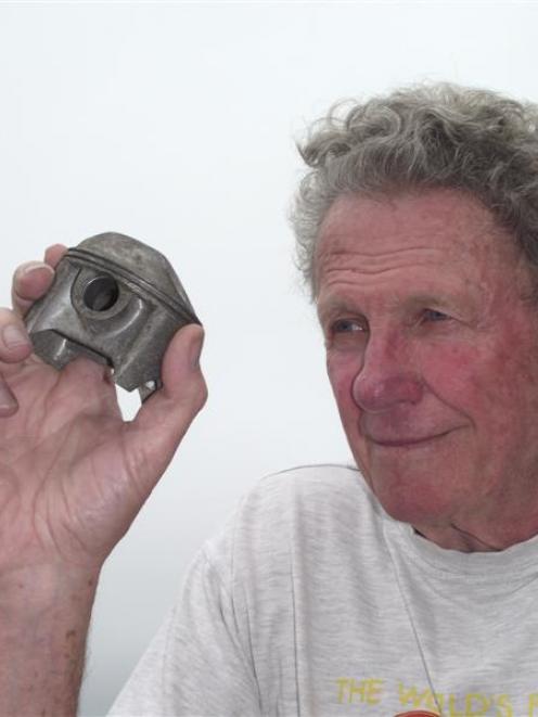 John Munro with a hand-made piston from his father's "World's Fastest Indian" motorcycle, which...