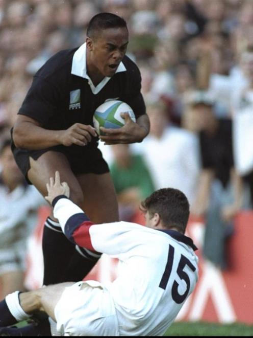 Jonah Lomu barrels through the tackle of England's Mike Catt to score a try during the All Blacks...