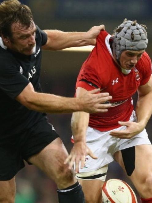 Jonathan Davies of Wales spills the ball under the challenge of Andrew Hore whose act of...