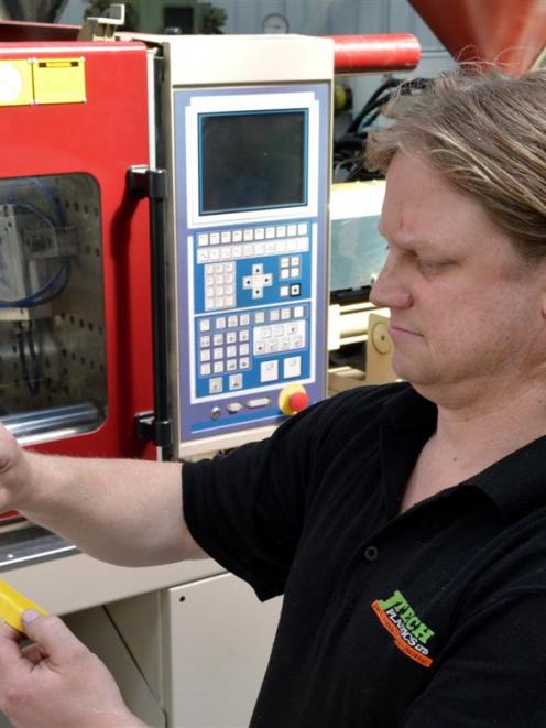 Jtech Plastics Ltd owner Jason Hollis checks the thickness of a product from the injection...