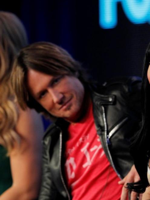 Judges Nicki Minaj (R), Keith Urban and Mariah Carey listen to a reporter's question at a Fox...