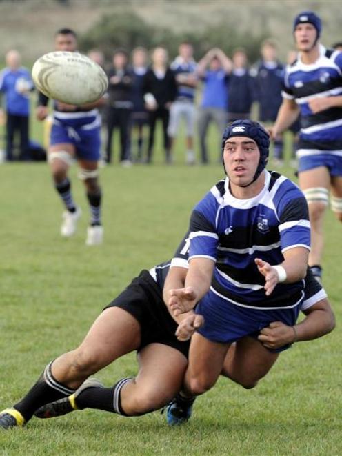 Kaikorai flanker Jamie Williams off-loads in the tackle of Pirates winger Repoamo Ai'iliolo at...
