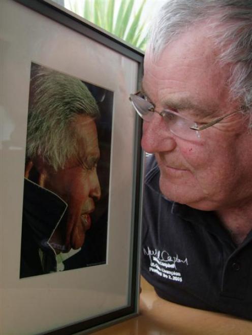 Kaka Point resident Norman Woods looks fondly at a photograph of the late poet Hone Tuwhare, who...