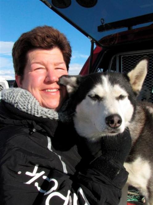 Karen Ramstead, of Canada, inspects Siberian husky Aladdin (8), of Clyde, before the start of the...