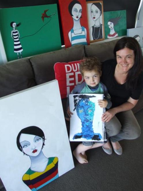 Kate Allan with some of her paintings, while younger son Ben (4) holds one of his artworks. Photo...