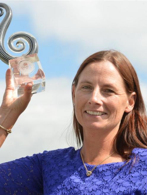 Katie Milne holds aloft her trophy after being announced Dairy Woman of the Year. Photo by...