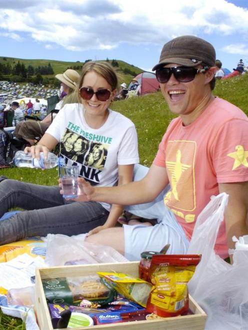 Katrina Dunlop (20), of Dunedin, pours a drink for Luke Dillon (26), of Auckland, while waiting...