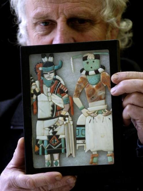 Kevin Hayward displays a pair of Zuni inlaid figurines, part of an online auction of North...