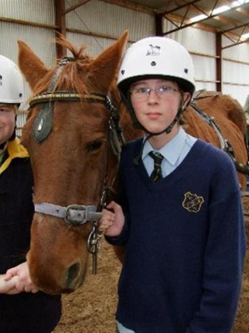 Nathan Coombes (17), left, and Jordan Poelstra (13) meet one of the horses at the Litchfield Park...