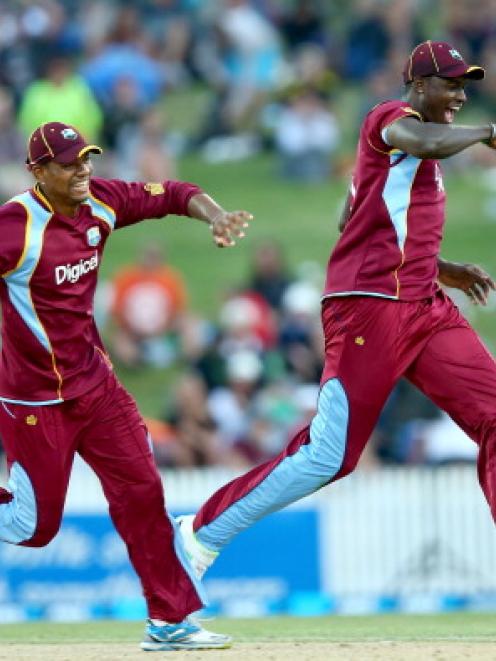 Kieran Powell (left) celebrates the game-winning run-out with Jason Holder as the West Indies...