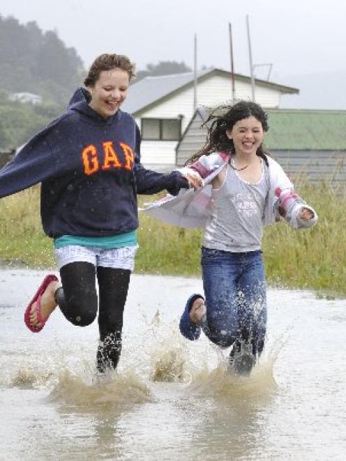 Kim Guetzkow (16), left, and Antonia Craig (10) make the most of the inclement weather at St...