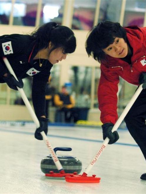 Kim Ji-Suk (left) and Kang Yoo-Ri, of Korea, compete in the women's curling at Maniototo Ice Rink...