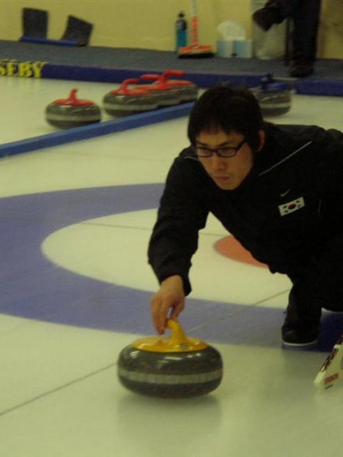 Korea team member Kim Soo-hyuk delivers a stone against New Zealand at the Maniototo Curling...