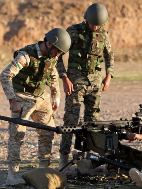 Kurdish Peshmerga fighters undergo training by British soldiers at a shooting range in Arbil, in...