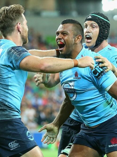 Kurtley Beale (C) is congratulated by Waratahs teammates after scoring a try against the Rebels....