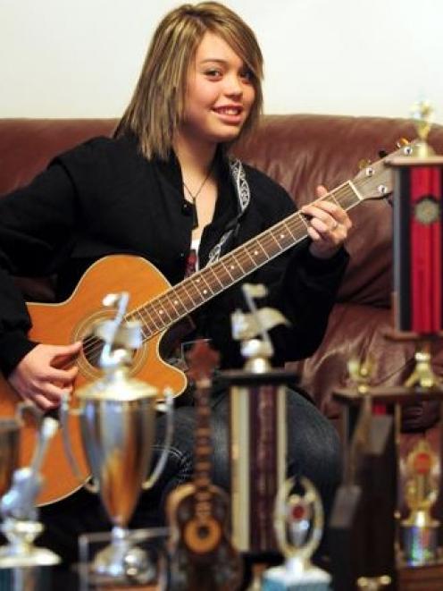 Dunedin musician Kylie Price (14) strums her six-stringed pride and joy and surveys her trophies....