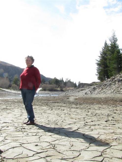 Lake Hawea Guardians chairwoman Barbara Chinn on the mudflat next to the control dam above the...