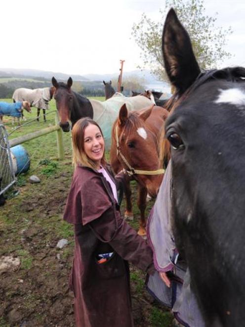 Highland Horse Haven director Lauren Moses walks with some of the horses being rehabilitated at...