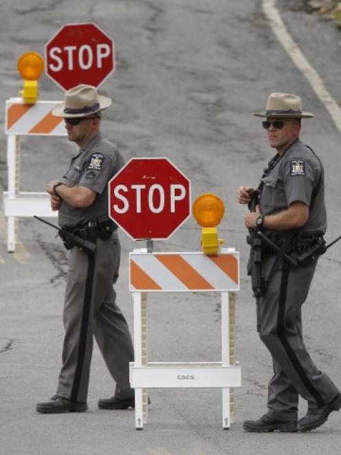 Law enforcement officers work a roadblock on the perimeter of a search area for David Sweat south...