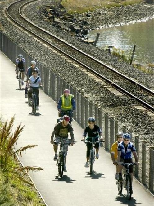 Leading the field are Dunedin Mayor Peter Chin, providing the second set of legs on a tandem bike...
