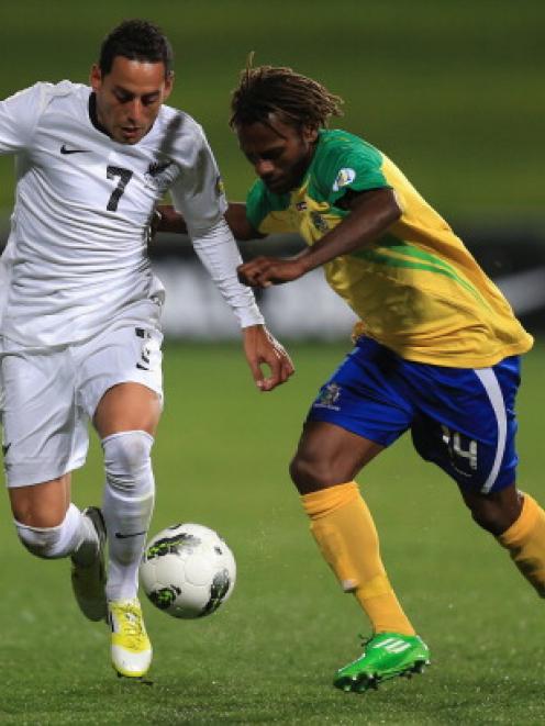 Leo Bertos of New Zealand and Joses Nawo of the Solomon Islands compete for the ball.  (Photo by...