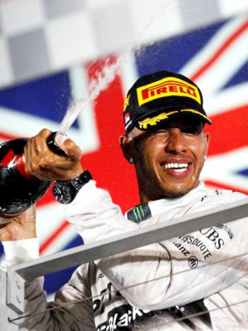 Lewis Hamilton sprays champagne on the podium following his win in the Singapore Grand Prix....