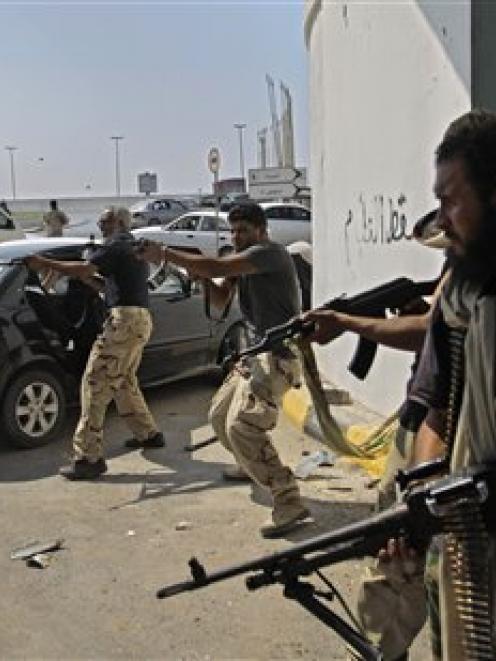 Libyan rebel fighters fire towards forces loyal to Muammar Gaddafi in downtown Tripoli, Libya. ...