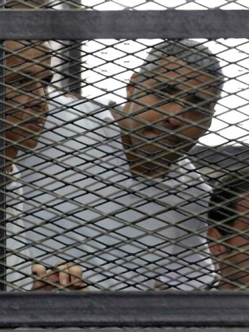 Listening to the ruling at a court in Cairo are (l-r) Peter Greste, Mohamed Fahmy and Baher...