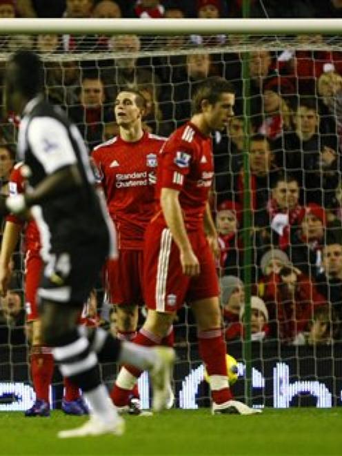 Liverpool's Daniel Agger, third right, looks on after scoring an own goal against Newcastle...