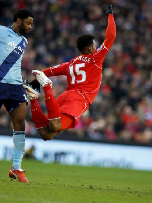 Liverpool's Daniel Sturridge falls after a foul by West Ham United's Alex Song (L). REUTERS/Phil...