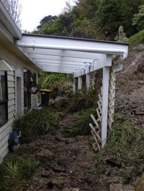 Lloyd Hiscock surveys the back of his Burkes Dr home, where tonnes of sodden mud from a bank was...