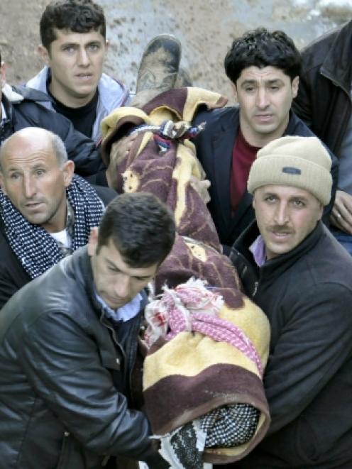 Locals carry a victim killed in air strikes to the morgue of a hospital in Uludere, of the Sirnak...