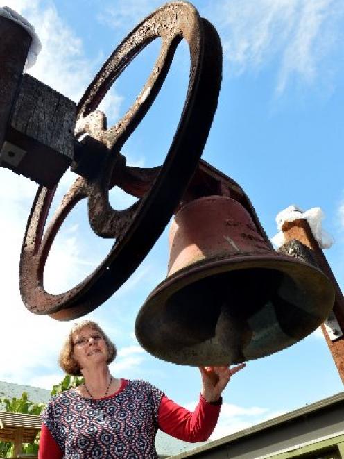 Logan Park High School principal Jane Johnson admires the 100-year-old bronze bell from King...