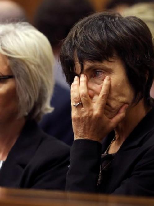 Lois Pistorius (L), the aunt of Oscar Pistorius, sits with an unidentified family member during...