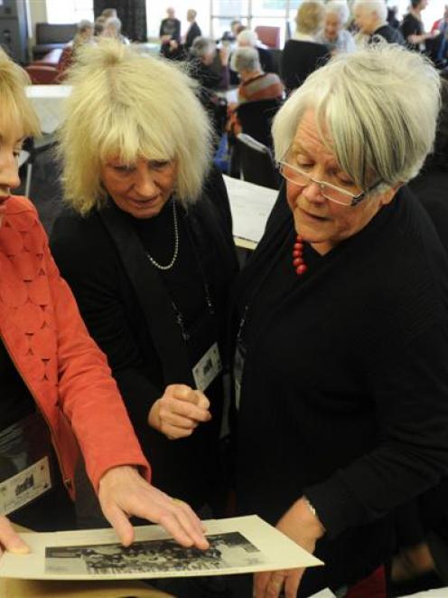 Looking through old photographs at a Dominican Hall reunion in Dunedin on Saturday are former...