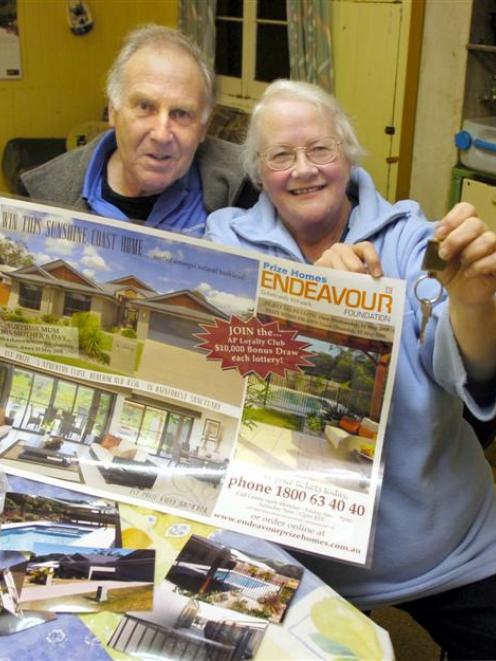 Cliff and Valerie Hall show the promotional material for the Queensland house they have won in a...