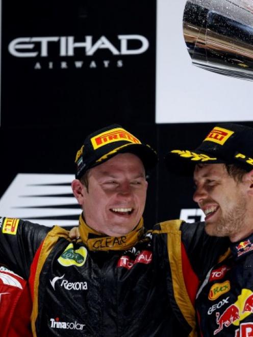 Lotus driver Kimi Raikkonen (C) of Finland celebrates, between Fernando Alonso (L, 2nd) of Spain...