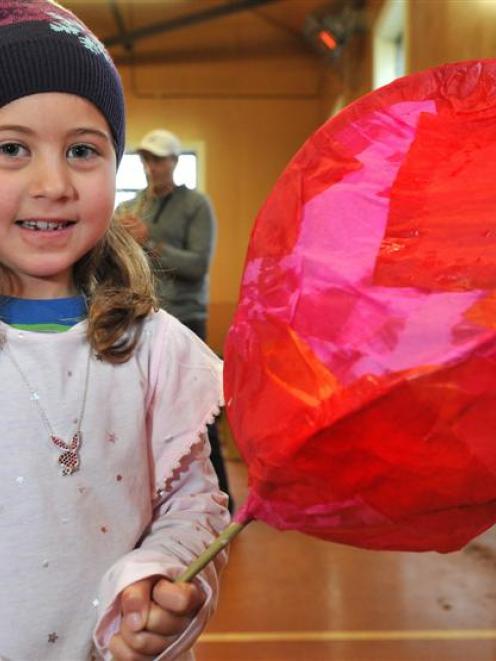 Luciana Brown Giraldo (6), of Dunedin, holds one of the flower lanterns she created during a...