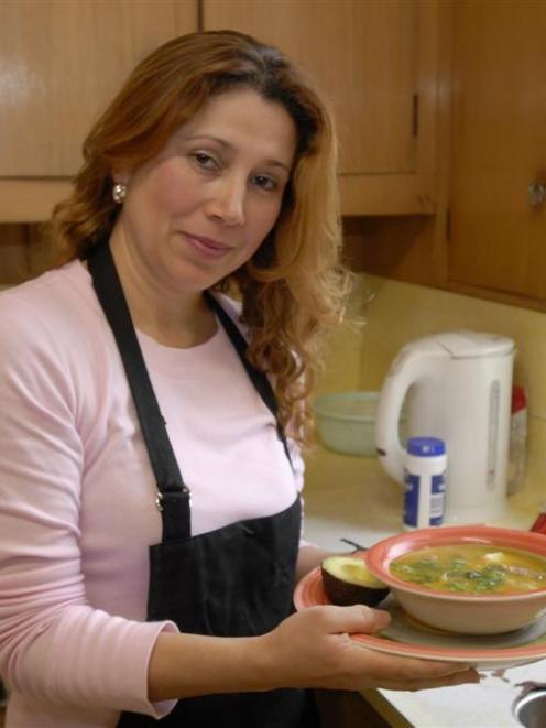 Luz Mery Johnstone holds a serving of sopa de arena. Photo by Gregor Richardson.