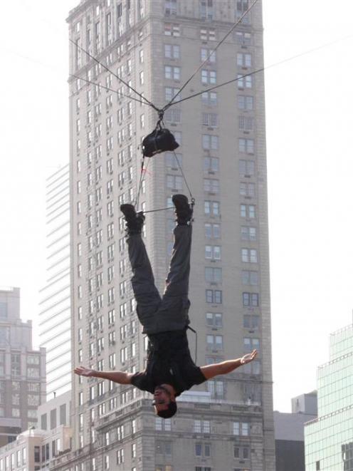 Magician David Blaine hangs upside down above Central Park's Wollman Rink in New York as he...