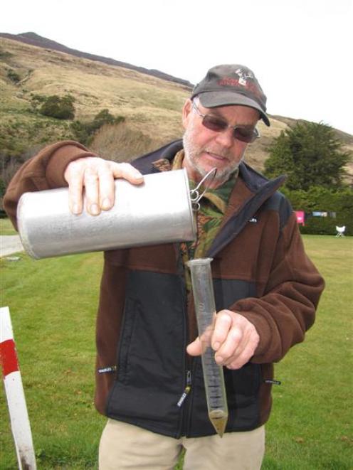 Makarora River Ranch hand Allan Cooper measures out the rain that officially ended Makarora's 29...
