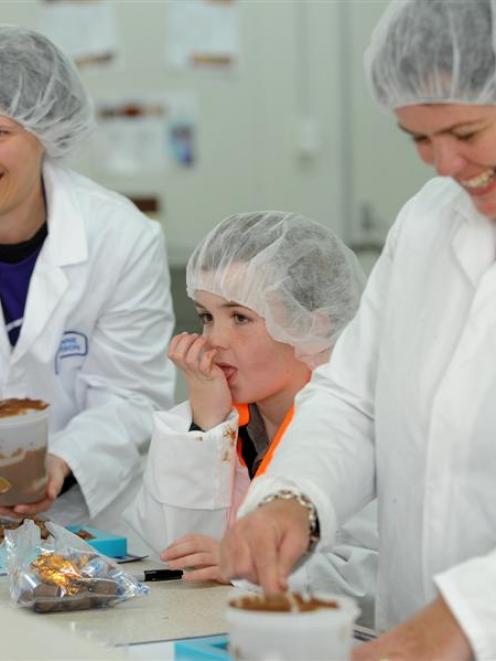 Making blocks of chocolate. Cure Kids ambassador William Currie gets a hand from Lee-Anne...