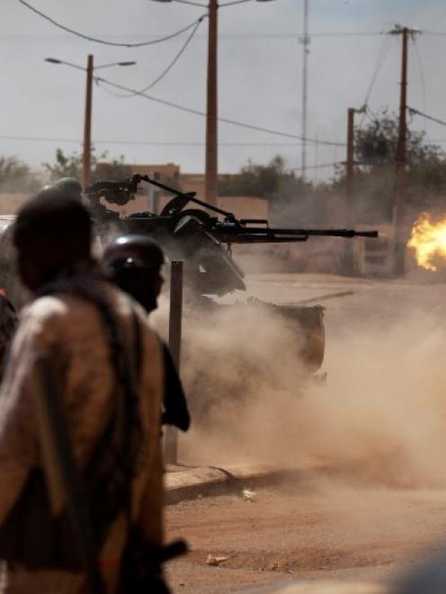 Malian soldiers fire a machine gun as they battle Islamists on the streets of Gao. REUTERS/Joe...